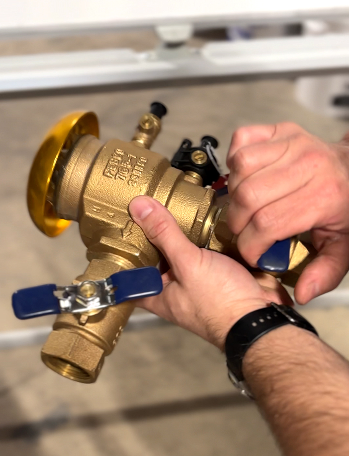 Team Bob's plumber holding backflow prevention device.