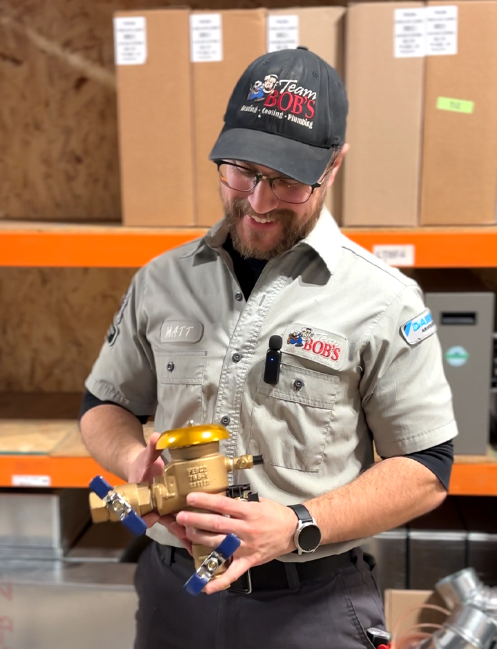 Team Bob's plumber showing backflow preventer.