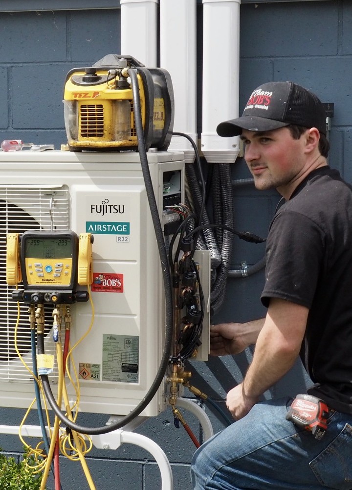 Air conditioning technician repairing AC unit in Traverse City MI